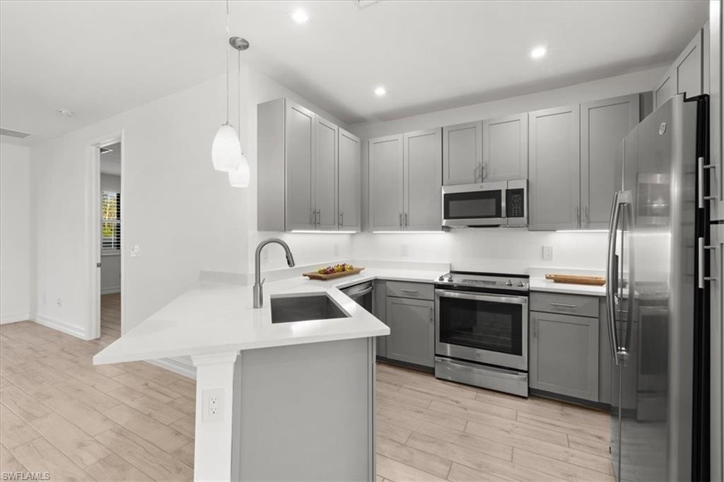 7622 Rockefeller Drive Naples, FL 34119 - Photo 5 of 40 a kitchen with stainless steel appliances granite countertop a sink stove and refrigerator
