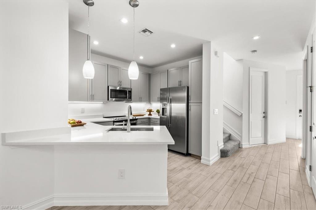 7622 Rockefeller Drive Naples, FL 34119 - Photo 7 of 40 a kitchen with stainless steel appliances a refrigerator sink and stove
