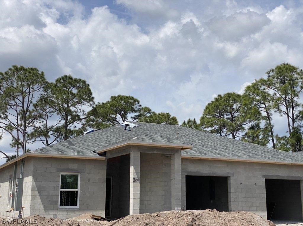 833-835 Meadow Road Lehigh Acres, FL 33973 - Photo 1 of 6 a front view of a house with a garden