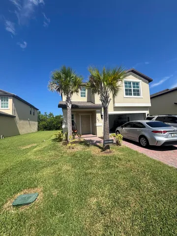 a front view of a house with a garden and yard