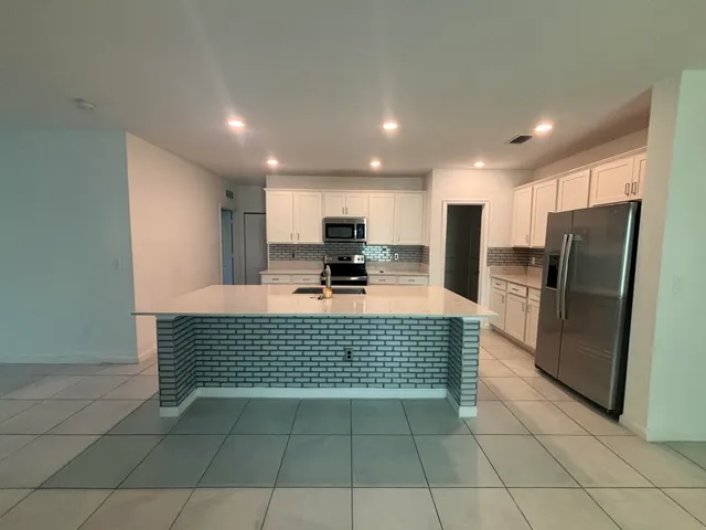 a kitchen with granite countertop a refrigerator and a counter top space