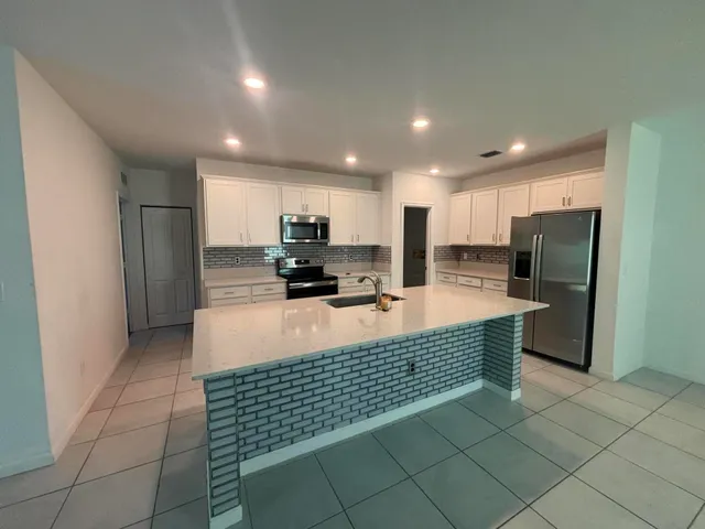 a kitchen with stainless steel appliances a refrigerator sink and cabinets