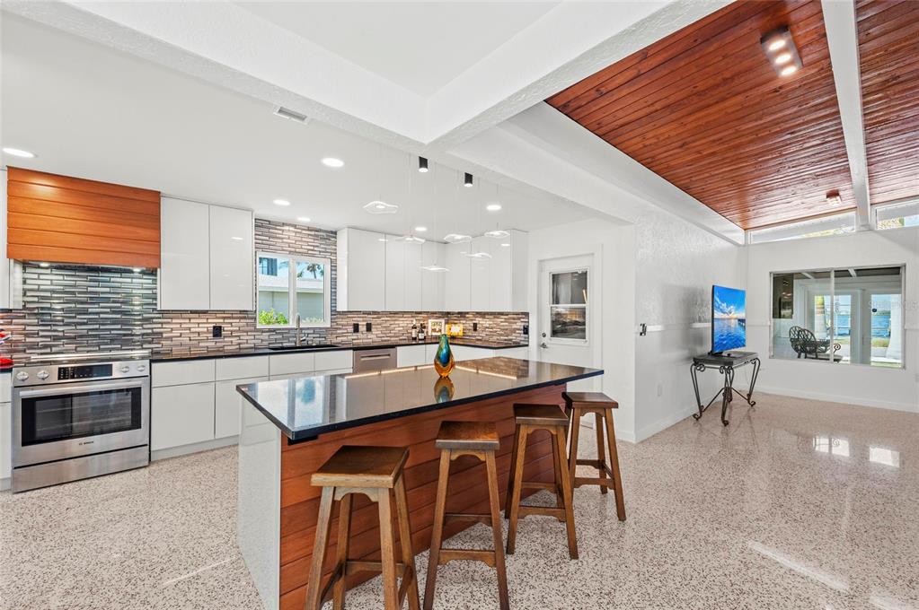 2014 Riverside Drive East Bradenton, FL 34208 - Photo 29 of 66 a kitchen with stainless steel appliances granite countertop table chairs sink and stove