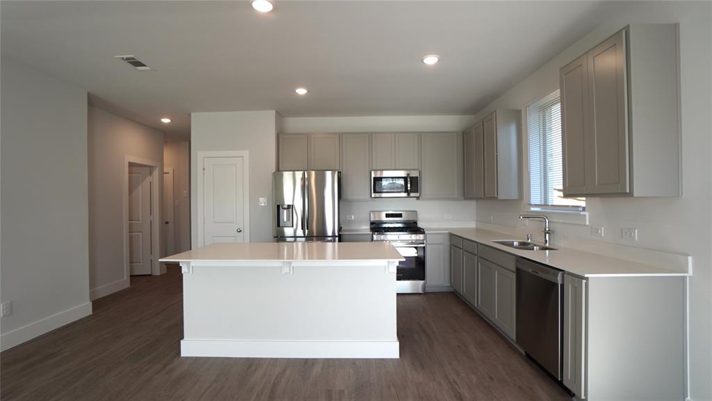1374 Chisos Way Forney, TX 75126 - Photo 7 of 25 a large kitchen with stainless steel appliances a large counter top a sink a stove and a refrigerator