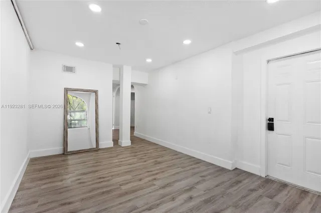 a view of an empty room with wooden floor