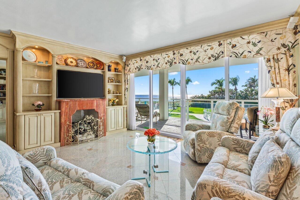1213 South Ocean Boulevard, Unit 2B Delray Beach, FL 33483 - Photo 11 of 43 a living room with furniture a flat screen tv and floor to ceiling window