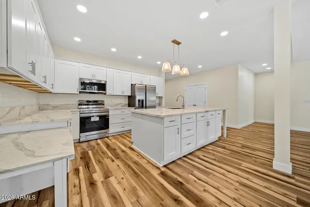 a large kitchen with kitchen island a sink stainless steel appliances and cabinets