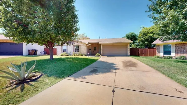 a front view of a house with a garden and yard