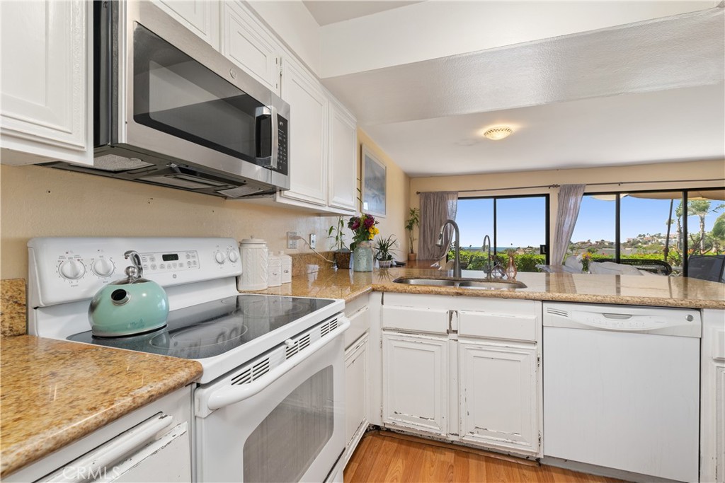 567 Avenida Adobe San Clemente, CA 92672 - Photo 14 of 33 a kitchen with cabinets appliances a sink and a counter top space