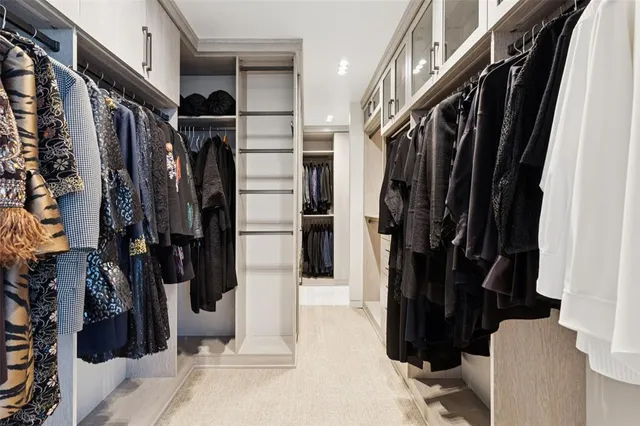 a view of walk in closet with clothes and shoes