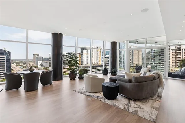 a living room with furniture a large window and a wooden floor