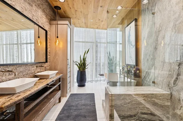 a spacious bathroom with a granite countertop double vanity and a mirror