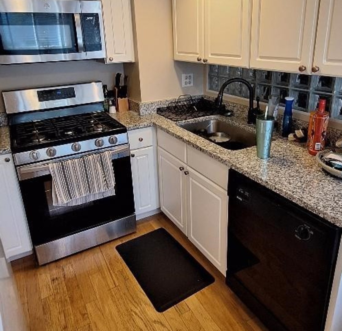 514 Inverrary Lane, Unit C Deerfield, IL 60015 - Photo 5 of 10 a kitchen with granite countertop a sink dishwasher stove and cabinets