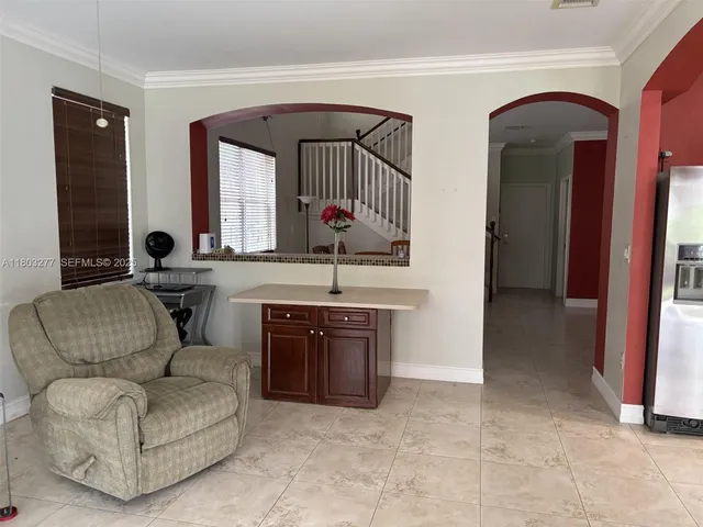 a living room with couches and a large mirror with wooden floor