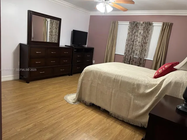 a bedroom with a bed and a flat tv screen on dresser