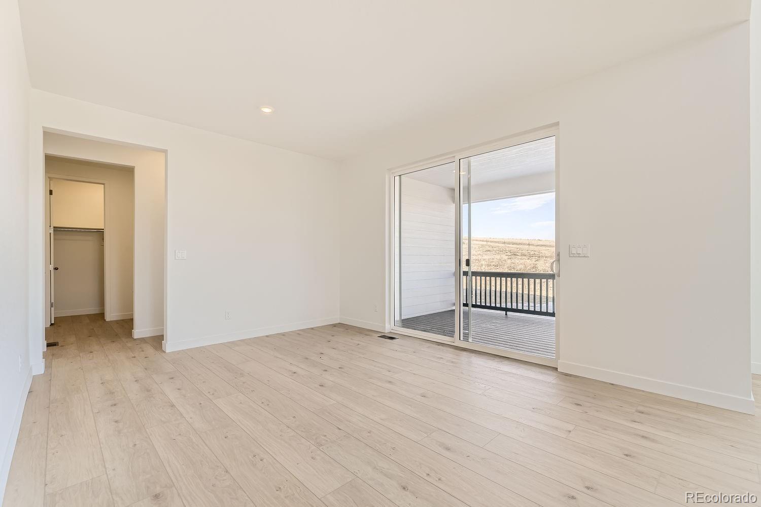907 Congress Place Elizabeth, CO 80107 - Photo 6 of 19 an empty room with wooden floor and windows