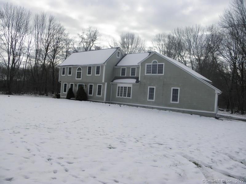 a front view of a house with a yard covered in snow