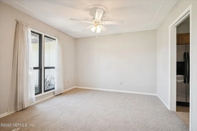 an empty room with a window and a ceiling fan