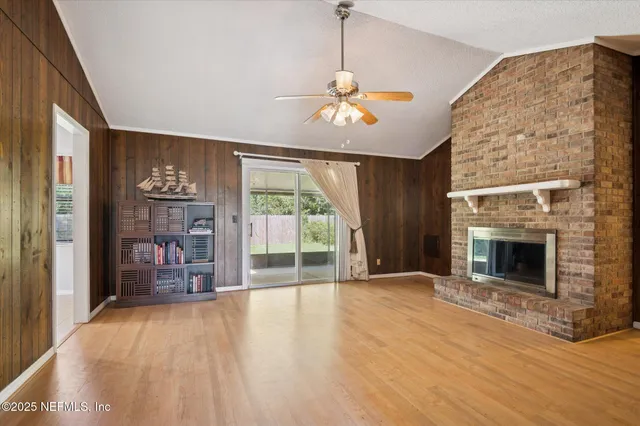 a view of an empty room with a fireplace and a window