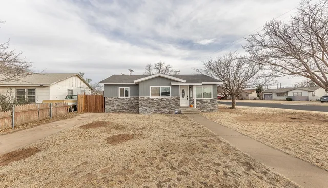 a view of house with yard and sitting area