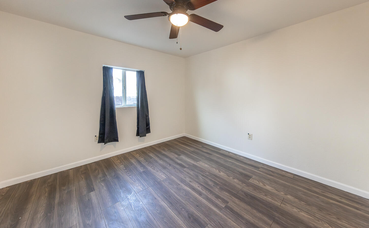 2002 65th Street Lubbock, TX 79412 - Photo 14 of 25 an empty room with wooden floor chandelier fan and windows