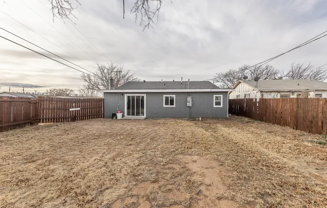 a front view of a house with a yard and a wooden fence