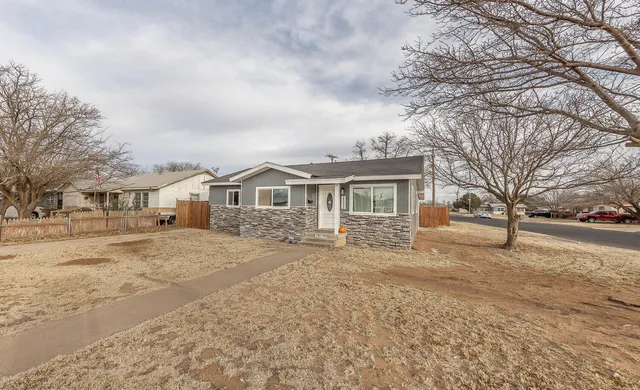 a front view of a house with a yard covered in snow