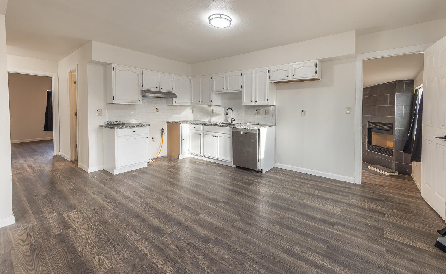 2002 65th Street Lubbock, TX 79412 - Photo 6 of 25 a kitchen with granite countertop white cabinets and wooden floor