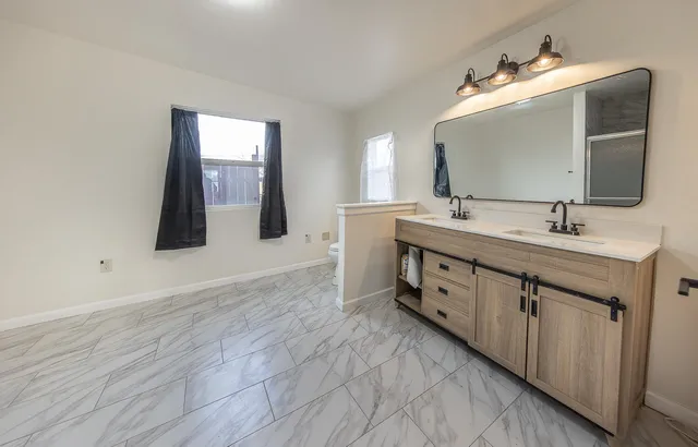 a bathroom with a double vanity sink and mirror