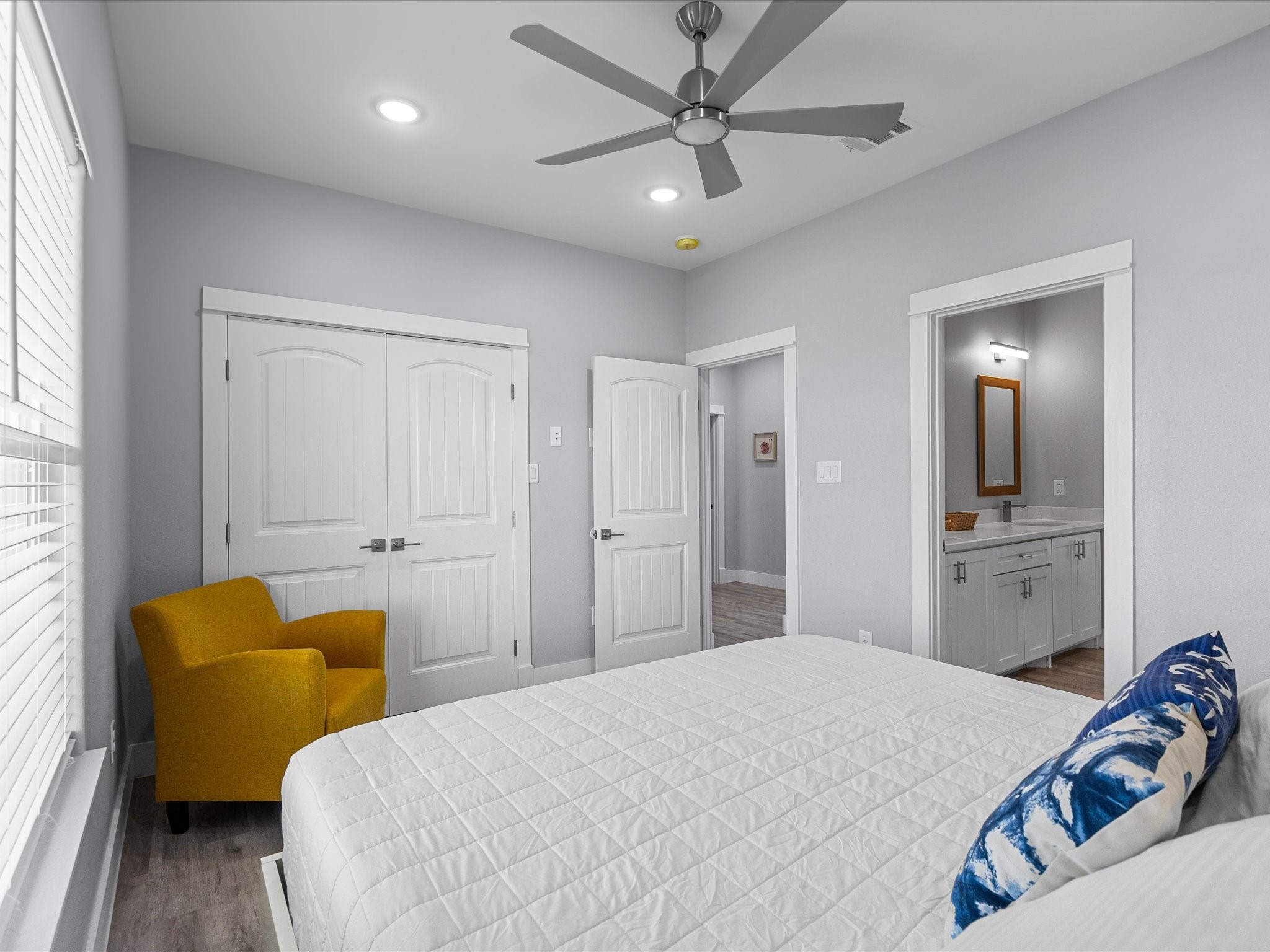 718 Beach Drive Surfside Beach, TX 77541 - Photo 35 of 49 This inviting bedroom, with modern gray walls and wood flooring, features bunk beds and an extra bed, perfect for hosting guests. Sunlight streams through the window, creating a bright and welcoming atmosphere.