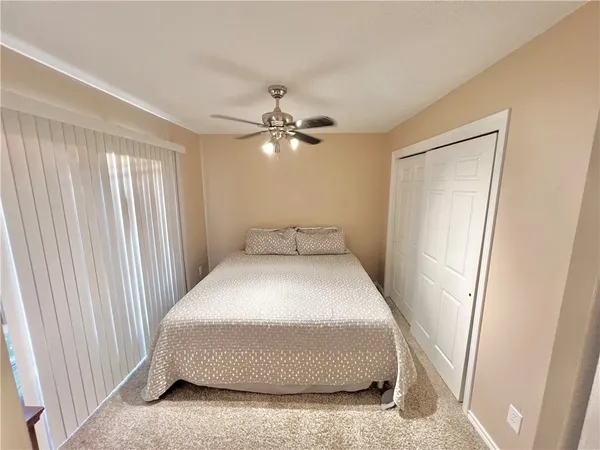 a bedroom with a bed and a ceiling fan