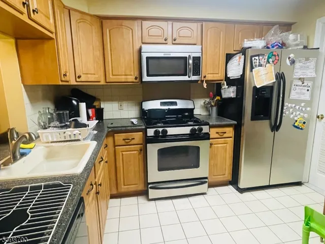 a kitchen with stainless steel appliances a stove a microwave and a sink