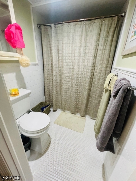 3 Quartz Lane, Unit 3 Paterson, NJ 07501 - Photo 8 of 10 a white toilet sitting next to a shower curtain