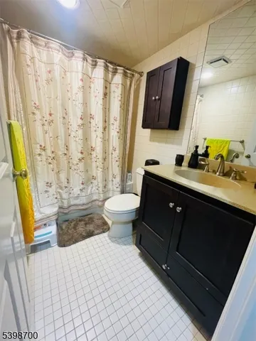 a bathroom with a double vanity sink toilet and a tub