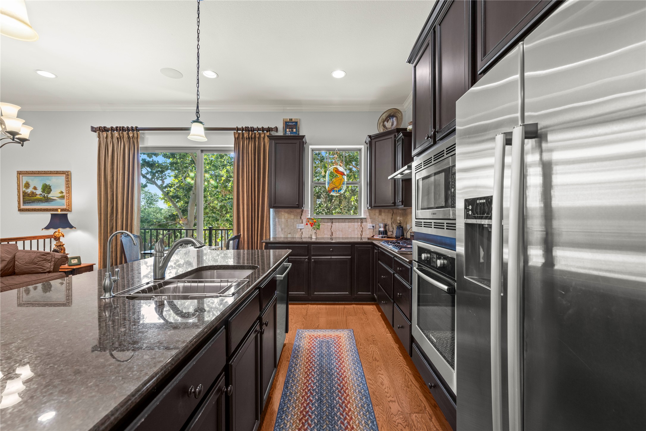 204 Adams Street Georgetown, TX 78628 - Photo 7 of 33 Culinary delights await in this modern kitchen, boasting sleek granite countertops and premium stainless steel appliances.