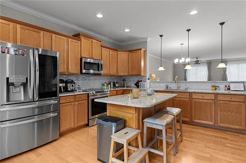2744 Blakely Drive Northeast Suwanee, GA 30024 - Photo 11 of 45 a kitchen with stainless steel appliances granite countertop a refrigerator a sink a stove a microwave and wooden cabinets