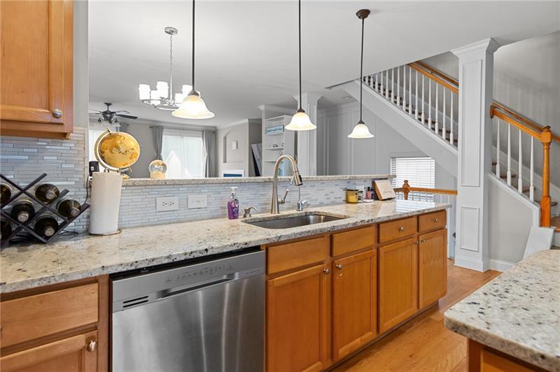 2744 Blakely Drive Northeast Suwanee, GA 30024 - Photo 14 of 45 a kitchen with a sink a island a stove and a wooden floor