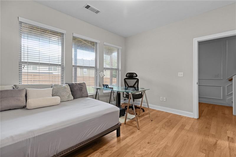 2744 Blakely Drive Northeast Suwanee, GA 30024 - Photo 23 of 45 a bedroom with a bed a table and a dresser next to a window