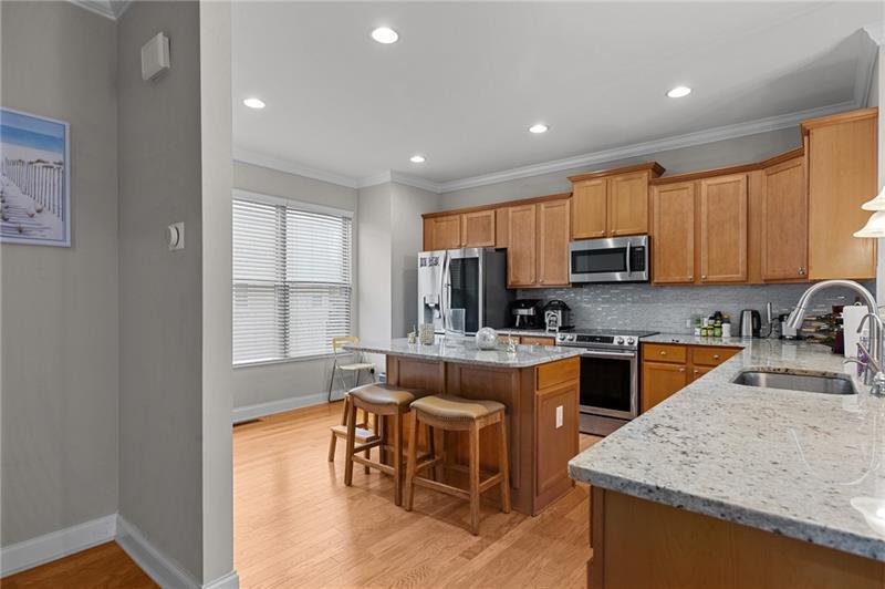 2744 Blakely Drive Northeast Suwanee, GA 30024 - Photo 10 of 45 a kitchen with stainless steel appliances granite countertop sink stove top oven and microwave