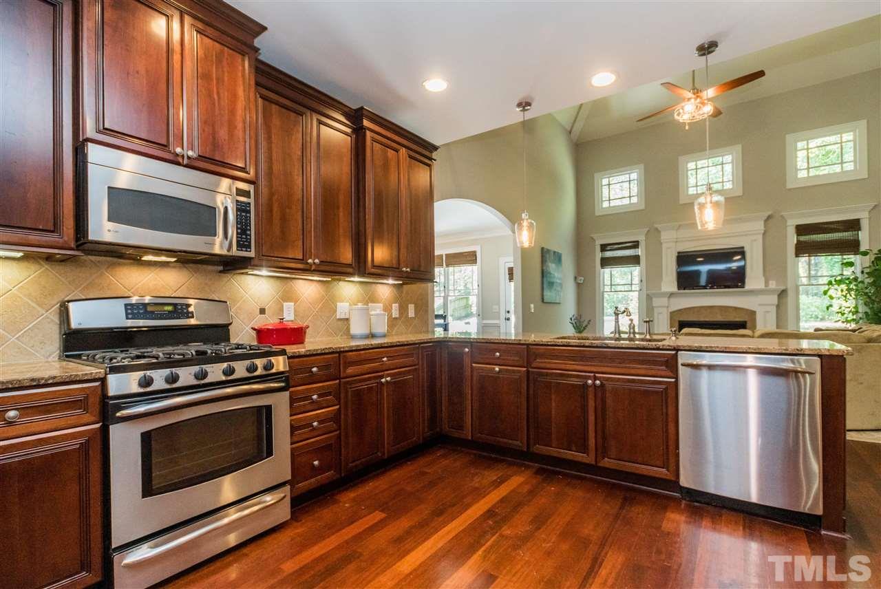 1407 Nottingham Road Raleigh, NC 27607 - Photo 12 of 30 a kitchen with stainless steel appliances granite countertop wooden cabinets stove top oven and sink