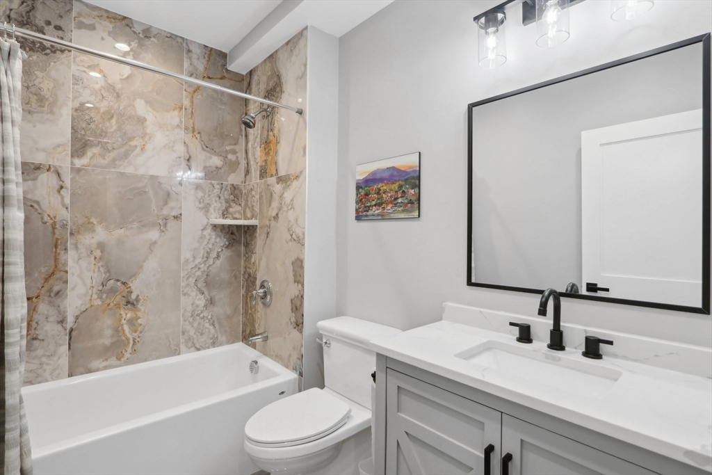 49 A Chestnut Street, Unit 1 Wakefield, MA 01880 - Photo 15 of 22 a bathroom with a sink a toilet and a bathtub