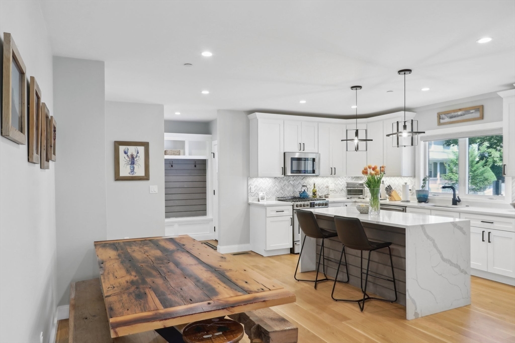 49 A Chestnut Street, Unit 1 Wakefield, MA 01880 - Photo 6 of 22 a kitchen with a table chairs refrigerator and cabinets
