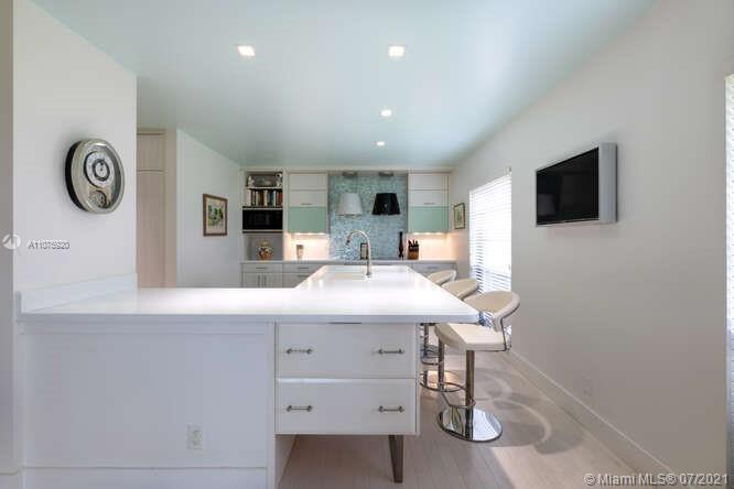 275 South Beach Road, Unit A103 Tequesta, FL 33469 - Photo 12 of 35 a view of kitchen with sink microwave and refrigerator