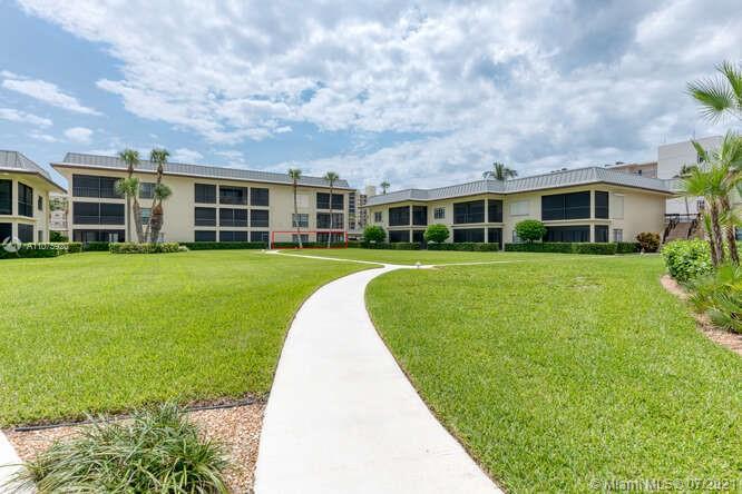 275 South Beach Road, Unit A103 Tequesta, FL 33469 - Photo 31 of 35 a view of a house next to a big yard and large trees