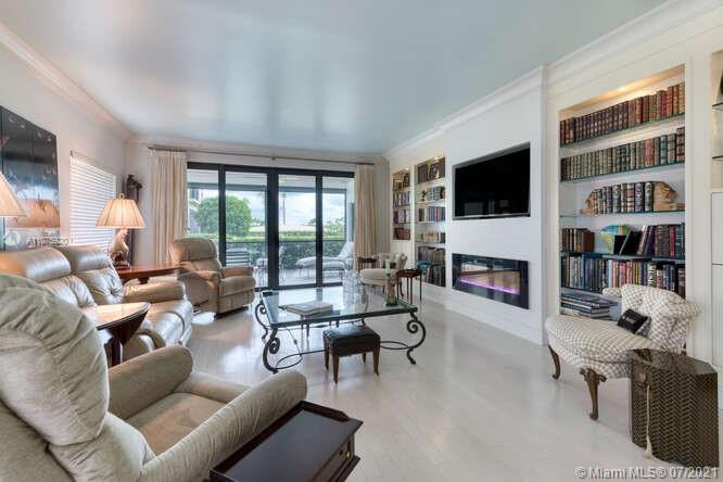 275 South Beach Road, Unit A103 Tequesta, FL 33469 - Photo 8 of 35 a living room with furniture a fireplace and a flat screen tv