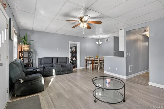 a living room with furniture a fireplace and a chandelier