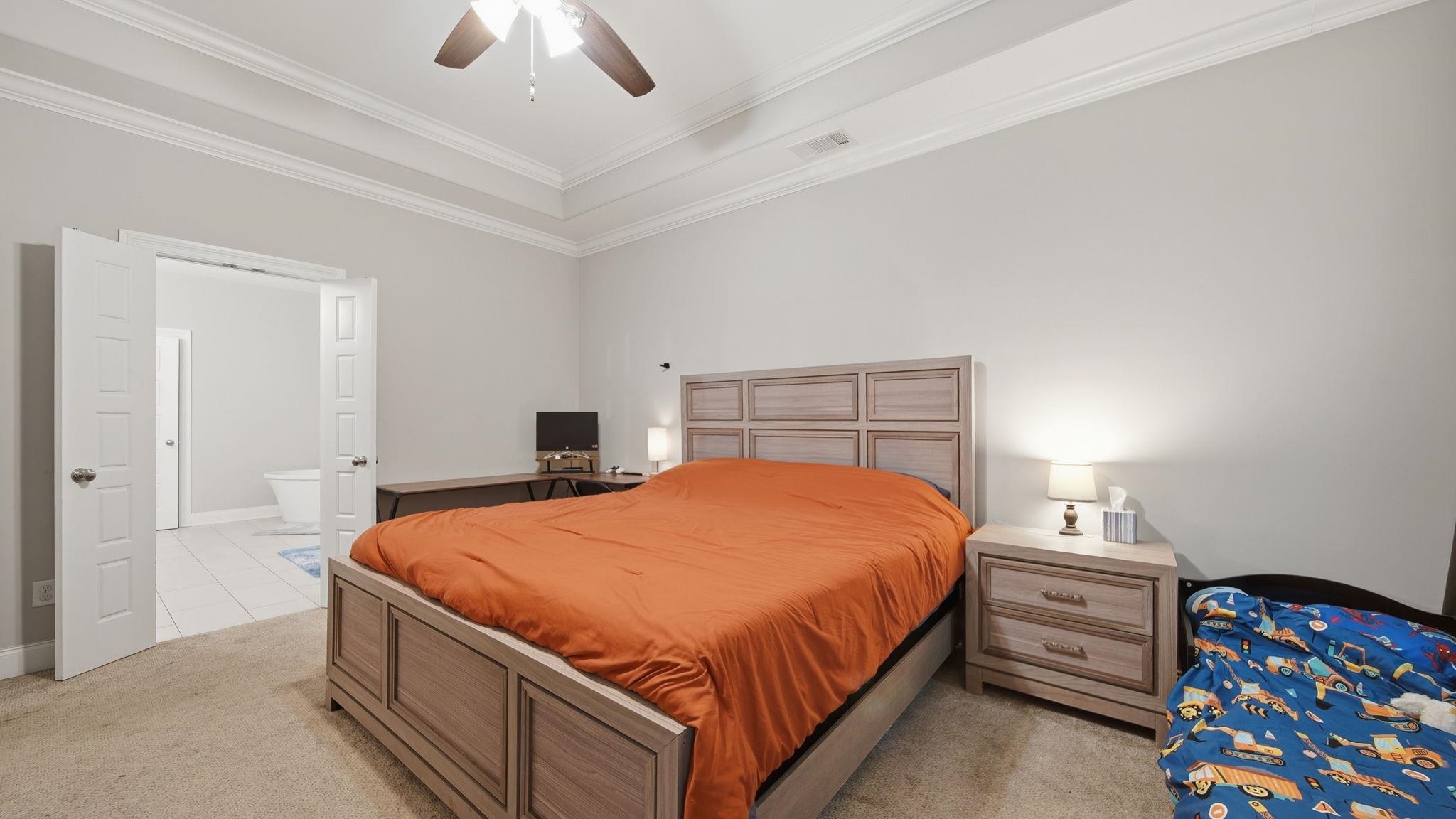 70 Trinity Cove Atoka, TN 38004 - Photo 9 of 25 Carpeted bedroom featuring a tray ceiling, crown molding, and a ceiling fan with integrated lighting