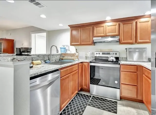 a kitchen with stainless steel appliances granite countertop a sink stove and cabinets