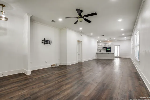 a view of empty room with wooden floor and window