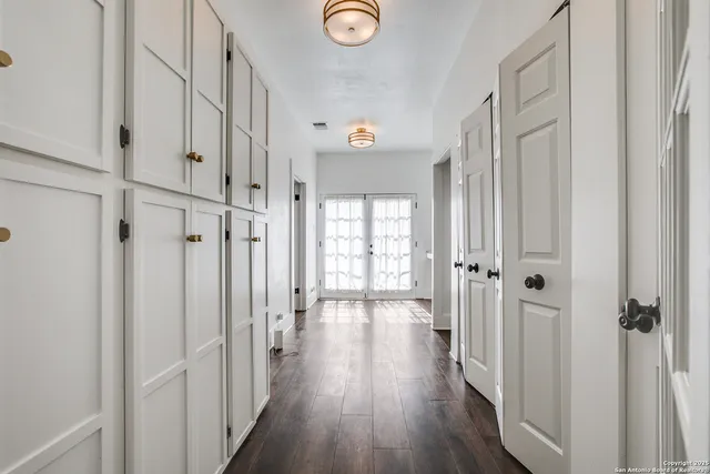 a view of a hallway with wooden floor and closet area
